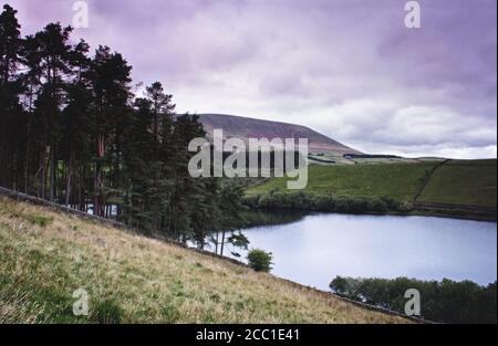 Una lontana collina di Pendle, vista dalle pendici di Barley, adiacente al bacino idrico di Ogden e al bosco locale Foto Stock