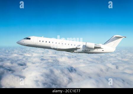 L'aereo passeggeri vola a livello di volo sullo sfondo di nuvole e di un cielo blu Foto Stock