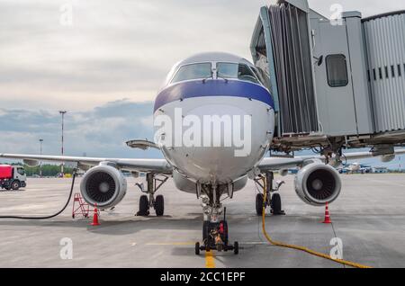 L'aeromobile è collegato alla passerella terminale del edificio dell'aeroporto durante il rifornimento prima del volo Foto Stock