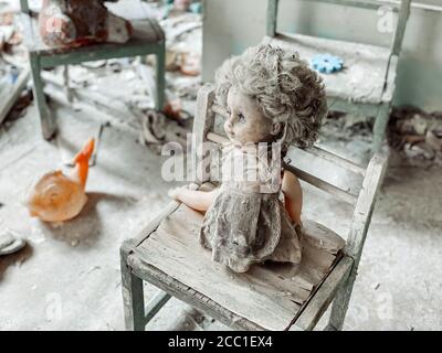 Giocattoli per bambini coperti di polvere e detriti nelle rovine di una casa abbandonata. Case abbandonate e distrutte dopo l'incidente al Chernobyl nu Foto Stock