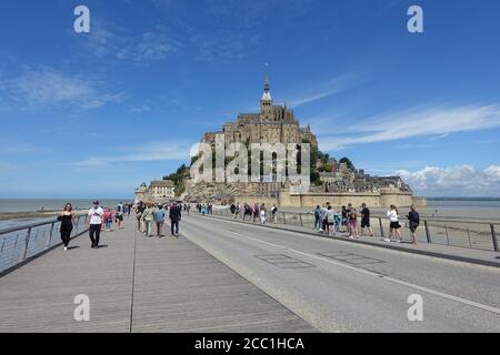 Mont St Michel, Francia: Luglio 2020: Turisti che visitano il famoso punto di riferimento di Mont St Michel nel Nord della Francia Foto Stock