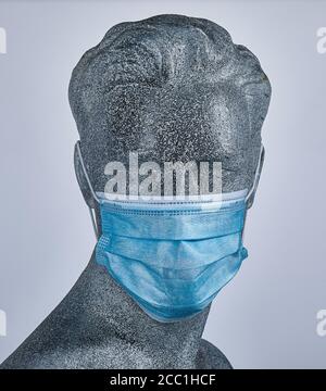 Manichino da esposizione maschile, indossando una maschera medica protettiva per il viso, su sfondo grigio Foto Stock