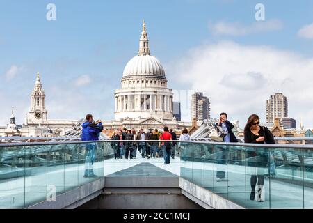 Turisti e pendolari sul Millennium Bridge, la cupola della Cattedrale di St Paul sullo sfondo, Bankside, Londra, Regno Unito Foto Stock