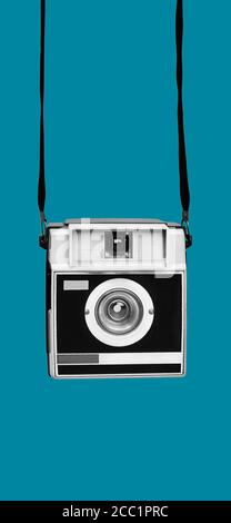 una telecamera retrò, in bianco e nero, su sfondo blu, in formato verticale da utilizzare per storie mobili o come sfondo per smartphone Foto Stock