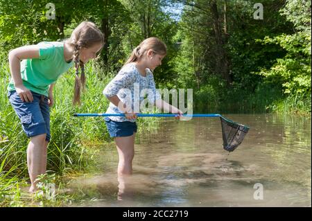 In Germania, in Baviera, Monaco di Baviera, ragazze con rete da pesca nel lago Foto Stock