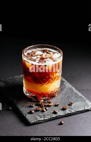 bicchiere di coctail alcolico con ghiaccio su sfondo nero Foto Stock