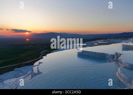 La Turchia, vista delle terrazze di travertino di Pamukkale al tramonto Foto Stock