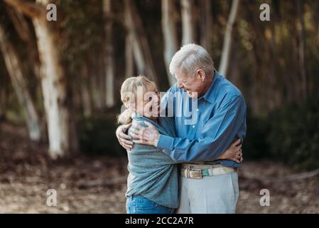 Ritratto di coppia adulta anziana abbracciata nella foresta Foto Stock