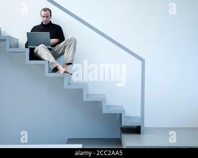 Giovane uomo utilizzando laptop Foto Stock