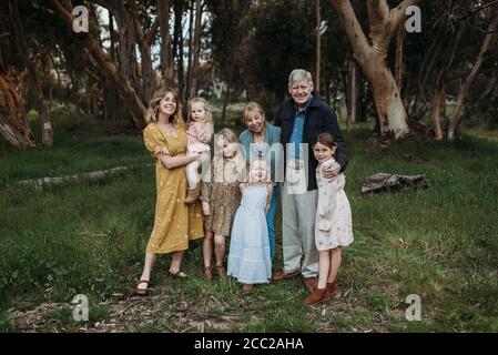 Ritratto di famiglia multigenerazionale sorridente e abbracciante nel campo Foto Stock