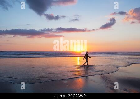 Nuova Zelanda, vista di donna matura camminando lungo la spiaggia Foto Stock