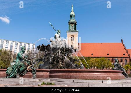 Germania, Berlino, Vista della fontana di Neptunbrunnen con la Chiesa di San Marys sullo sfondo Foto Stock