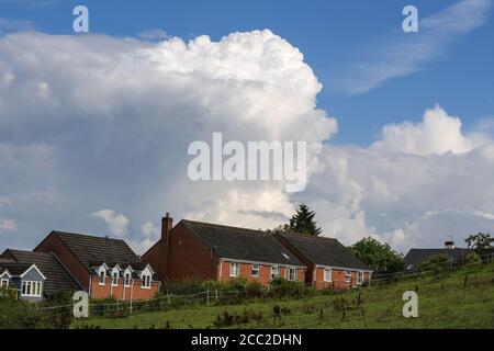 Romsley, Worcestershire, 17 agosto 2020. Il lunedì pomeriggio si formavano spettacolari nuvole sulle case di Romsley, Worcestershire, mentre il tuono e i fulmini continuavano a formarsi durante il caldo. Le piogge torrenziali hanno colpito la regione, ma si prevede che si calmeranno nella settimana successiva. Credito: Interrompi stampa Media/Alamy Live News Foto Stock