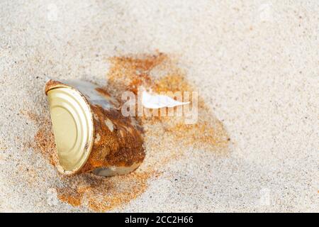 un vecchio stagno arrugginito può essere lasciato da un uomo su una spiaggia di sabbia. Foto Stock