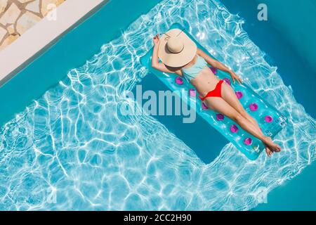 Vista dall'alto di una ragazza in un bikini che galleggia su un lilo in una piscina, Lefkada, Isole IONIE, Grecia