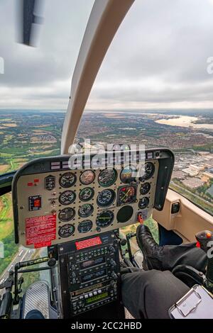 Vista aerea verticale del pannello di controllo nell'abitacolo di un elicottero che sorvola Thurrock, Essex . Foto Stock