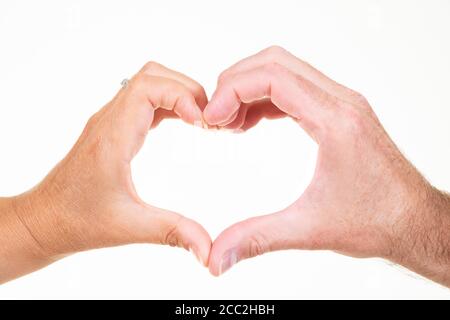 Primo piano orizzontale di un uomo e di una donna che fanno il simbolo del cuore della mano su uno sfondo bianco. Foto Stock