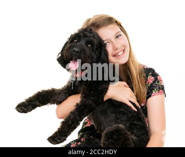 Ritratto orizzontale di una giovane ragazza con il suo cane da compagnia su sfondo bianco in uno studio o chiave alta. Foto Stock