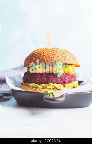 Hamburger vegano con cotoletta di barbabietole, salsa di patate dolci e guacamole. Foto Stock