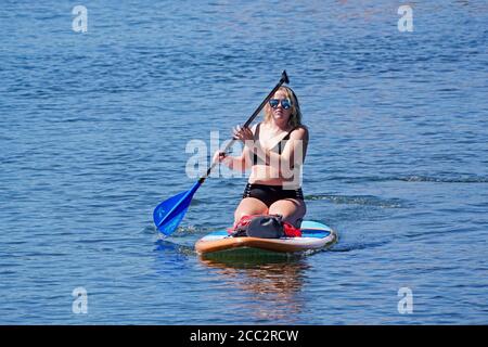 Turisti che utilizzano il fiume Deschutes a Bend, Oregon, durante l'estate. Il fiume è un luogo popolare per ratteri, galleggianti, paddleboarding e kaya Foto Stock