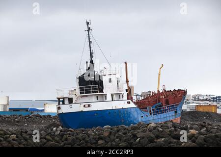 La nave da traino industriale si trova su una costa rocciosa nel porto di Reykjavik, Islanda. Vista Stern Foto Stock