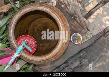 La canna in ceramica con acqua per uso domestico in campagna tailandese. Bagno all'aperto in cortile di casa in Asia. Foto Stock