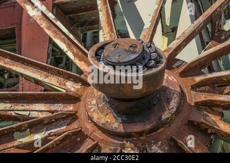 Vecchia ruota di metallo arrugginita in una miniera di carbone abbandonata Foto Stock