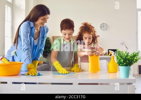 Camera per la pulizia della famiglia insieme e divertirsi. I capretti che aiutano il genitore a fare i chores domestici a casa Foto Stock