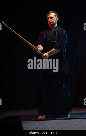 ritratto di caucasico uomo forte kendo combattente con bokuto. kendo guerriero maschio tenendo samurai spada katana Foto Stock