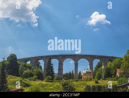 Viadotto ferroviario in pietra a Smrzovka, giorno estivo con cielo blu, montagne Jizera, repubblica Ceca Foto Stock