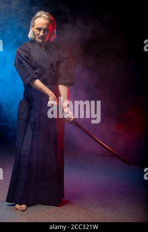 combattente caucasico maturo in abito con spada di bambù shinai , pratica lotta prima delle competizioni. arte marziale giapponese tradizionale concetto. isol Foto Stock