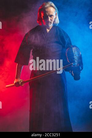 combattente caucasico maturo in abito con spada di bambù shinai , pratica lotta prima delle competizioni. arte marziale giapponese tradizionale concetto. isol Foto Stock