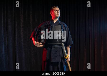 ritratto di combattente caucasico del kendo con bokuto, shinai di spada di bambù. arte marziale giapponese tradizionale di combattimento di spada Foto Stock