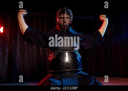 Combattente caucasico maschile kendo in stile tradizionale giapponese di abbigliamento, armatura protettiva, utilizzando shinai. Pratica lotta isolato Foto Stock