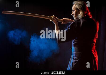 combattente caucasico forte in abiti tradizionali. arti marziali giapponesi, guerriero di combattimento, samurai concetto. uso di shinai per combattere Foto Stock