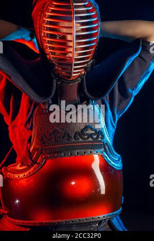 giovane combattente caucasico femminile del kendo che indossa la maschera, donna in tuta kendo appassionato di arte marziale tradizionale Foto Stock