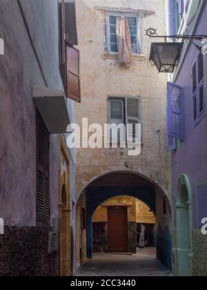 Case storiche viola e rosa nella medina di El Jadida, sagome di donne sullo sfondo, Marocco Foto Stock