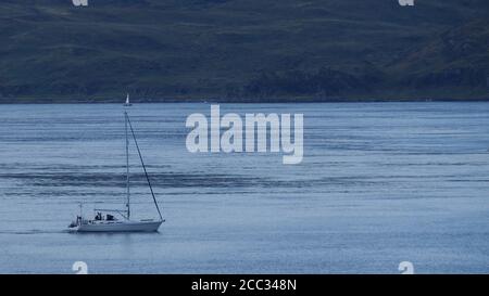 Un piccolo yacht in motorizzazione nel Sound of Jura, Scozia occidentale, al porto di Melfort in una giornata estiva limpida che mostra il mare blu, il cielo e l'isola oltre Foto Stock