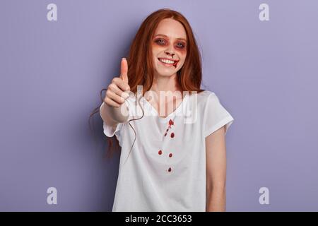 giovane ragazza positiva con brutto volto dipinto che gioisce a festa horror, primo piano ritratto, migliore vacanza, felicità, sensazione positiva e commozione concep Foto Stock