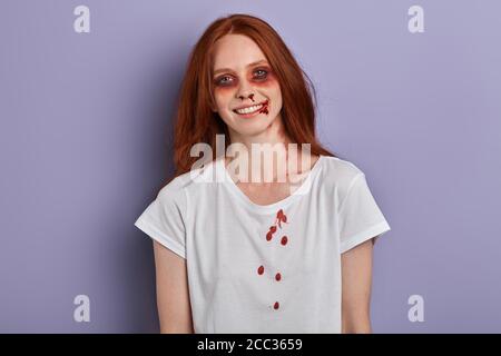 Tema di Halloween. Felice allegra zenzero ragazza che partecipa alla festa di Halloween. Primo piano foto. Giovane studente divertirsi in vacanza , isolato blu ba Foto Stock