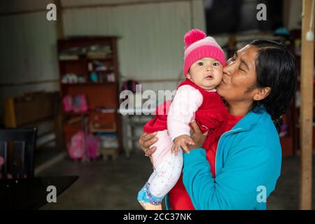 Ritratto di una madre e di un bambino insieme nella loro casa a Manchay Alto, distretto di Pachamac, Perù. Foto Stock