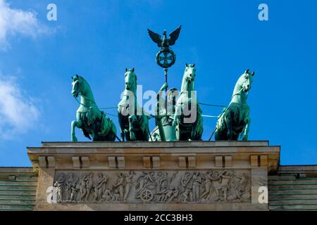 Una vista ravvicinata della quadriga che si erge sulla cima dell'iconica porta di Brandeburgo a Berlino. La statua presenta una dea (Victoria) che guida quattro ore Foto Stock