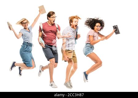 Entusiasti studenti multietnici con zaini e libri che saltano isolati bianco Foto Stock