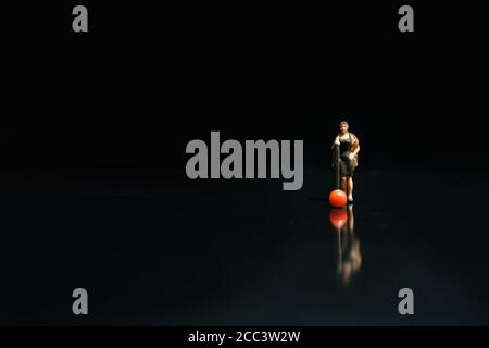 Fotografia in miniatura - elegante cantante femminile che canta su nero lucido palcoscenico con riflessione Foto Stock
