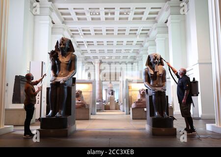 I manager della collezione Alex Truscott (a sinistra) e Evan York spolverano le statue di Amenhotep III (circa 1390-1352 a.C.), nella Egyptian Sculpture Gallery al British Museum di Londra, mentre si preparano a riaprire al pubblico il 27 agosto dopo il blocco del coronavirus. Prima della riapertura, il British Museum ha avviato il più grande programma di pulizia individuale degli ultimi decenni. Foto Stock