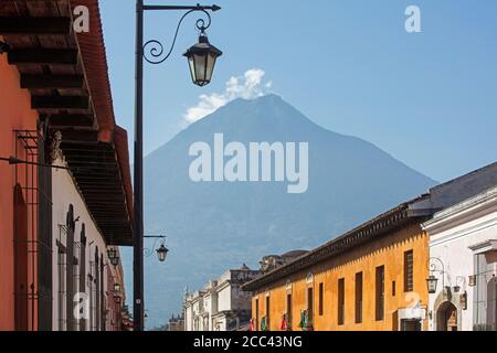 Volcán de Fuego vulcani e colorate case coloniali nella città Antigua Guatemala, Dipartimento Sacatepéquez, Guatemala, America Centrale Foto Stock
