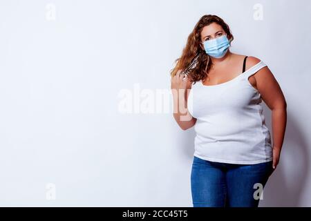 Ritratto di una bella donna bionda con oversize e volto maschera Foto Stock