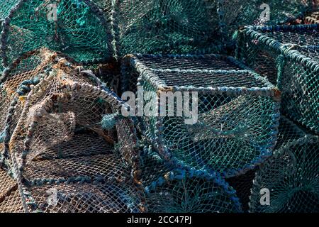 Pentole di aragosta accatastate su un molo sul mare Foto Stock