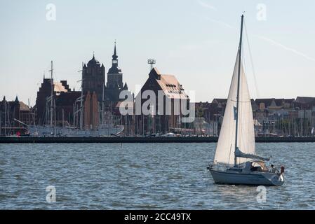 Stralsund, Germania. 13 Agosto 2020. Una barca a vela attraversa la città anseatica sullo Strelasund. Nel porto si trova la nave da vela Gorch Fock. Credit: Stefano Nosini/dpa-Zentralbild/ZB/dpa/Alamy Live News Foto Stock