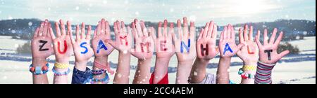 Kids Hands Holding Word Zusammenhalt significa togetherness, Snowy Winter background Foto Stock